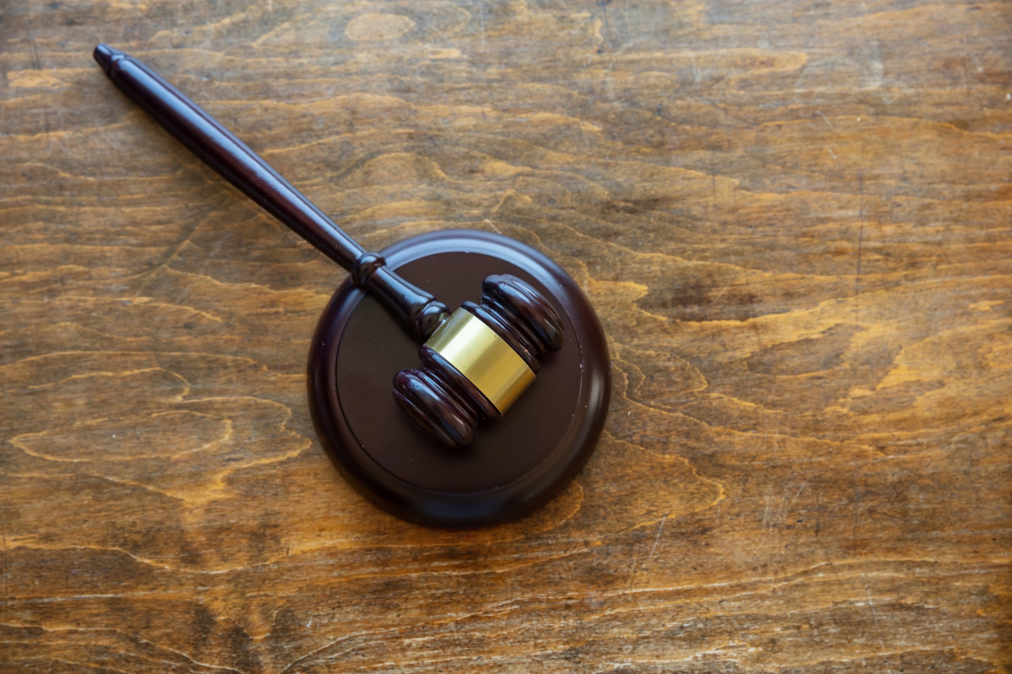 A judge's gavel resting on a wooden desk